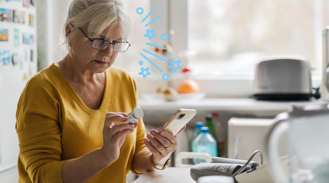 Frau in orangem Oberteil sitzt vor dem Handy