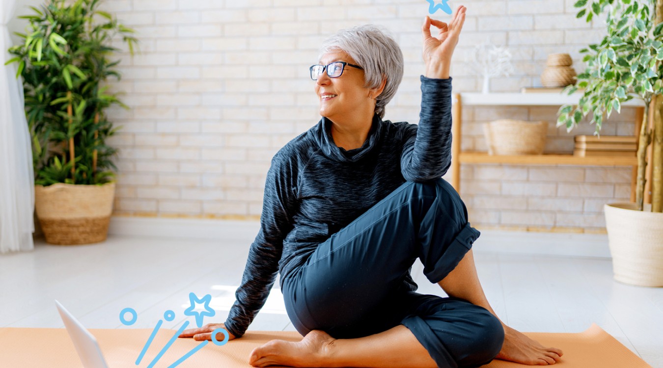 Frau sitzt auf Yogamatte und macht Yoga