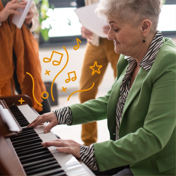 Frau mit grauen Haaren spielt am Klavier.