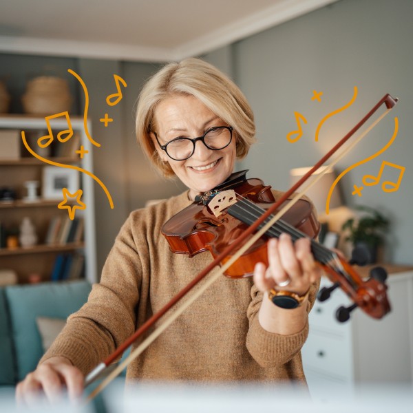 Ältere Frau mit blonden Haare spielt Geige.